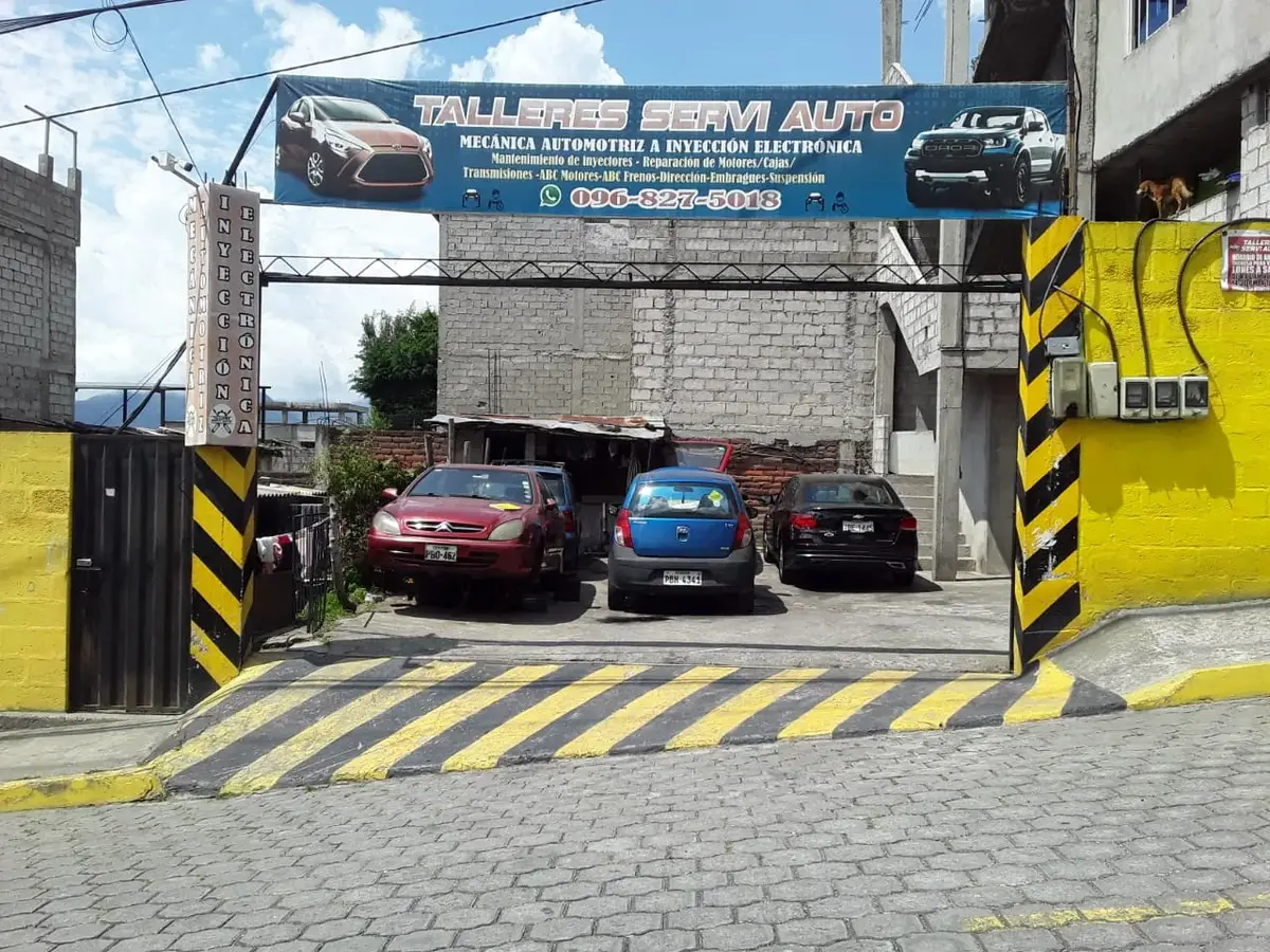Entrada de Talleres Servi Auto en Av. La Cocha: portón negro junto a la pared amarilla, Tréboles del Sur, sur de Quito